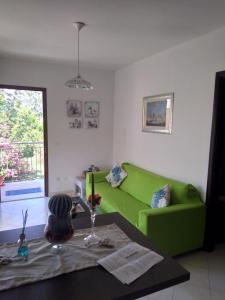 a living room with a green couch and a table at PIZZO BEACH CLUB 14F in Pizzo +51 photos
