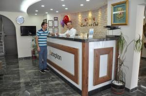 dos hombres parados en un mostrador en un salón en Konak EuroBest Otel en Konak