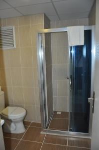 a bathroom with a toilet and a glass shower at Konak EuroBest Otel in Konak