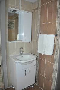 a bathroom with a sink and a mirror and towels at Konak EuroBest Otel in Konak