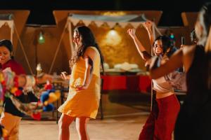 un grupo de jóvenes bailando en un escenario en The Mama's Resort & Camp, en Kūri