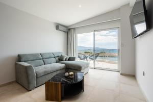 een woonkamer met een bank en een tafel bij Sail Away Home in Kalamata, Marina Serenity (B4) in Kalamata