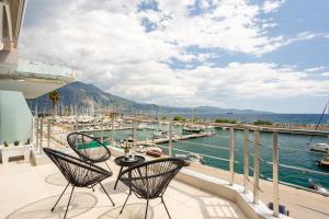 een balkon met 2 stoelen en een tafel en een jachthaven bij Sail Away Home in Kalamata, Marina Serenity (B4) in Kalamata