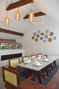 uma sala de jantar com uma mesa com cadeiras e pratos na parede em Athirige Private Villa Dharavandhoo em Dharavandhoo