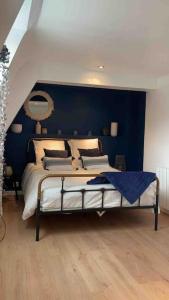 - une chambre avec un grand lit et un mur bleu dans l'établissement Maison 6 personnes 3 chambres proche grand stade Pierre mauroy, à Camphin-en-Pévèle