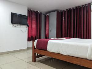 a bedroom with a bed and a flat screen tv at Green View Executive Stay's in Ernakulam