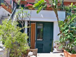 a house with a green door and some plants at Monolocale The Lair in Giardini Naxos