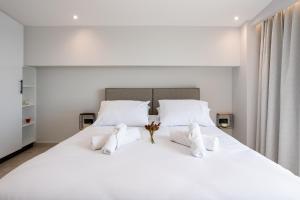 een slaapkamer met een groot wit bed met witte kussens bij Sail Away Home in Kalamata, Marina Serenity (B4) in Kalamata