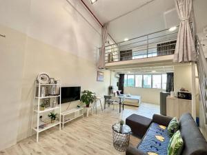 ein Wohnzimmer mit einem Sofa und einem TV in der Unterkunft CEO9 Duplex Premier Suite #2-7Pax#Pisa#USM#Pantai Hospital in Bayan Lepas