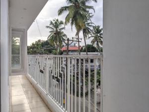 a balcony with a view of the beach and palm trees at Green View Executive Stay's in Ernakulam