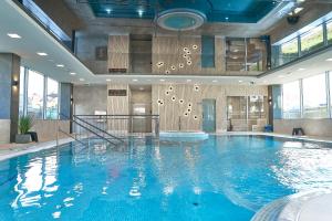 una grande piscina in un edificio con una grande piscina di SZAFIROWE APARTAMENTY 3 kryty basen i sauna RESORT KLIFOWA a Rewal