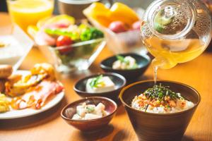 a table topped with bowls of food and a drink at KAYA Kyoto Nijo Castle, BW Signature Collection by Best Western in Kyoto