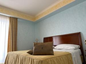 a bedroom with a bed with a wooden head board at Gardenia Hotel in Lazzaro
