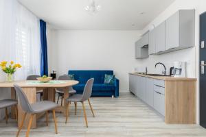 a kitchen and dining room with a table and chairs at Apartament nad Jeziorem Kołczewo - Ogród & Parking by Renters in Kołczewo