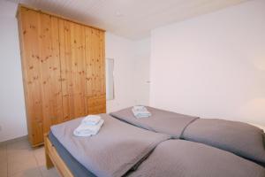 Ferienhaus Pelikanstr 129 Ostermann Bungalow 5 في نورديش: غرفة نوم بها سرير مع مناشف عليه