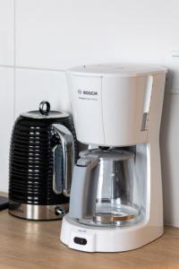 a white coffee maker sitting on top of a counter at Apartament nad Jeziorem Kołczewo - Ogród & Parking by Renters in Kołczewo