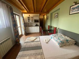 a bedroom with a bed and a kitchen with a table at Zajazd Tadeo in Pietrzykowice