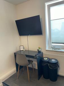 - un bureau avec une chaise et deux poubelles dans l'établissement MR Ferienwohnung - Einzelzimmer Frieda, à Schellerten 2 autres photos