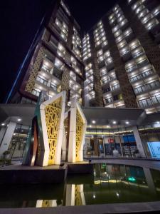 - un bâtiment avec une piscine en face de lui la nuit dans l'établissement 2 kamar Amarta apartemen By Tempattinggaljog, à Kejayan
