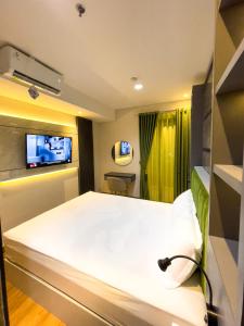 - une chambre à l'hôpital avec un lit et une télévision dans l'établissement 2 kamar Amarta apartemen By Tempattinggaljog, à Kejayan