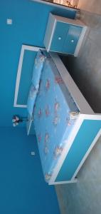 a blue bed with a tie hanging from a drawer at Ciza e Rose in Portela