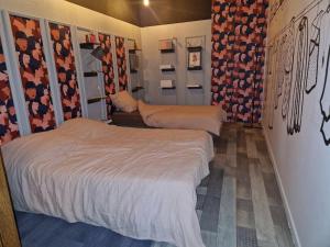 two beds in a small room with flowers on the walls at O centre in Saint-Avold