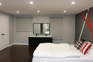 a bedroom with a white bed and a flat screen tv at Quiet and Contemporary Home in Markham