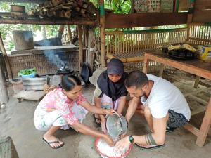 un gruppo di tre persone che giocano con un piatto di Bunga Maliq Bungalow Lombok a Tetebatu