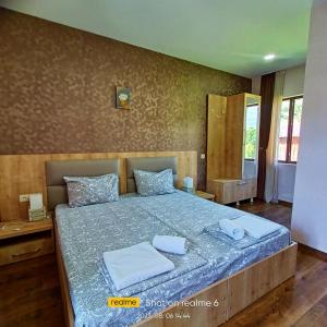 a bedroom with a bed with two towels on it at B&B House in Mestia