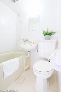a white bathroom with a toilet and a sink at NEW Heart of Shibuya Prime Studio, Kamiyama Inn! in Tokyo