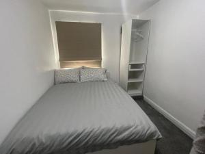 - une petite chambre avec un lit et un placard dans l'établissement Femros Apartments, 15mins to city center., à Smethwick