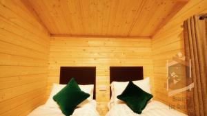 a bedroom with two beds in a wooden room at Glendaloch B&B in Antrim