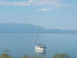 a boat sitting in the middle of a large body of water at Doma Menidi Rooftop Apartment in Menídion