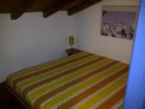 ロッカルメーラにあるCasa Sole Mareのベッドルーム1室(黄色のストライプ毛布付きのベッド1台付)