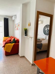- un salon avec un canapé et un miroir dans l'établissement Right by the pool area in Capistrano Village!, à Nerja
