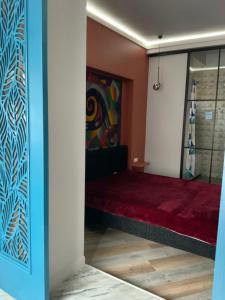 een kamer met een bed en een schilderij aan de muur bij Квартира в историческом центре Шымкента in Simkent