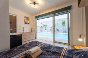 a bedroom with a bed and a bathroom with a pool at Villa LAtibulum in Saint-Pierre