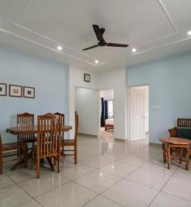 sala de estar con mesa, sillas y techo en Green View Executive Stay's en Ernakulam