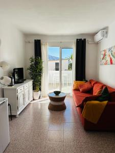a living room with a couch and a table at Right by the pool area in Capistrano Village! in Nerja