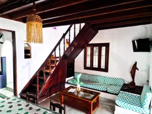 a living room with green couches and a staircase at VILLA AMNESYA NOSY BE in Nosy Be