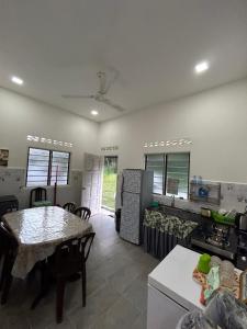 uma cozinha e sala de jantar com mesa e cadeiras em Teratak Cikgu Din em Marang