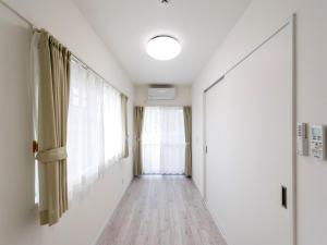 a hallway with white walls and a window at Hotel Tomas Nago in Nago