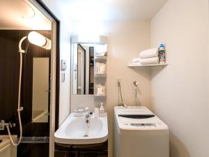 a white bathroom with a sink and a mirror at Hotel Tomas Nago in Nago