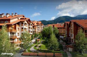 a group of buildings in a town with mountains at Luxory aparthotel in 4 star SPA hotel st Ivan Rilski, Bansko in Bansko
