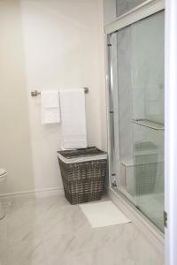 een badkamer met een douche, een mand en handdoeken bij Quiet and Contemporary Home in Markham