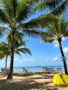 dos palmeras en una playa con sillas y el océano en Lucee 4 bedrooms apartment Phu Quoc, en Phu Quoc
