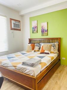 a large bed in a room with green walls at Mesavirre Garden Residences in Bantud Hacienda