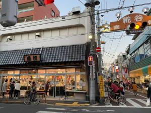 a street corner with a store with people on bikes at EK House Kamata A, Simple&Stylish, Near Haneda/Shinagawa, one floor in Tokyo