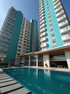 a swimming pool in front of two tall buildings at Mesavirre Garden Residences in Bantud Hacienda