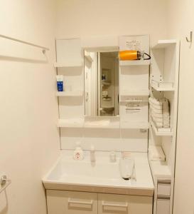 a white bathroom with a sink and a mirror at EK House Kamata A, Simple&Stylish, Near Haneda/Shinagawa, one floor in Tokyo